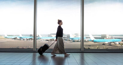 Woman with suitcase rushing to the check in for the flight at the airport