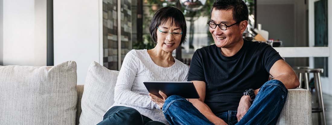 Couple sitting on couch looking at tablet. What is a Fixed Deferred Annuity.  