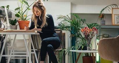 Businesswoman Sitting At Her Desk At Home And Working. How to Write a Business Plan.
