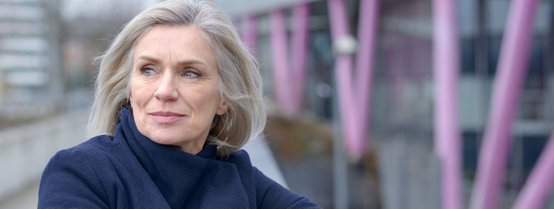 Mature woman sitting outdoors.  Find Disability Survivors Benefits.