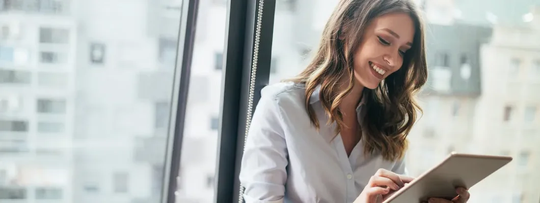 Businesswoman using a digital tablet while standing in front of windows. Find Narbet, Pennsylvania Business Insurance. 