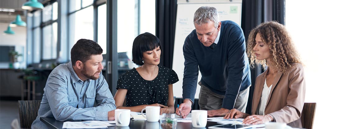 Employees collaborating in office setting. Florida Business Umbrella Insurance.