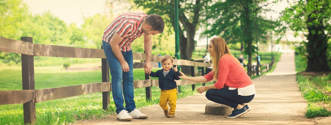 Parents and their baby boy learning to walk