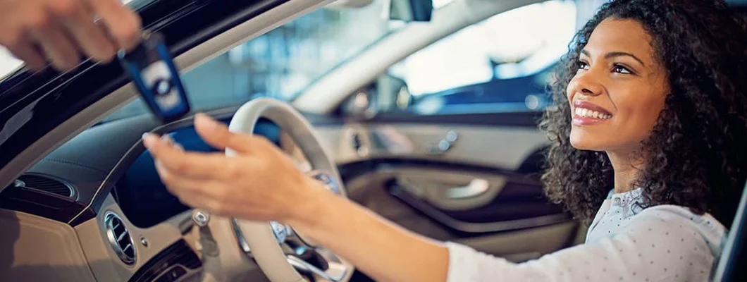 Car dealer is giving key for a new car to a businesswoman. How to Find the Best Car Insurance Policy in Moorestown, NJ. 