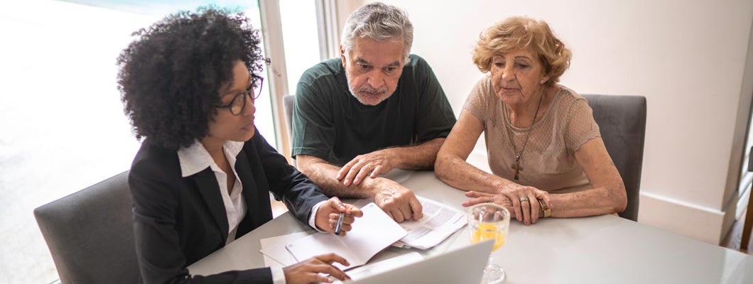Independent insurance agent helping a senior couple at home with their annuities. Annuity shares.