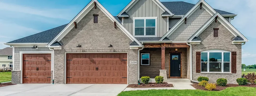 Brown three car garage with olive paint on the rest of the house. How to Find the Best Homeowners Insurance in Florissant, Missouri.