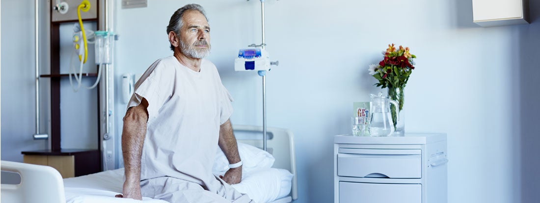 Man looking away while sitting on bed in hospital ward. How Much Does Long-Term Individual Disability Insurance Cost?