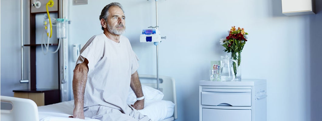 Man looking away while sitting on bed in hospital ward. How Much Does Long-Term Individual Disability Insurance Cost?