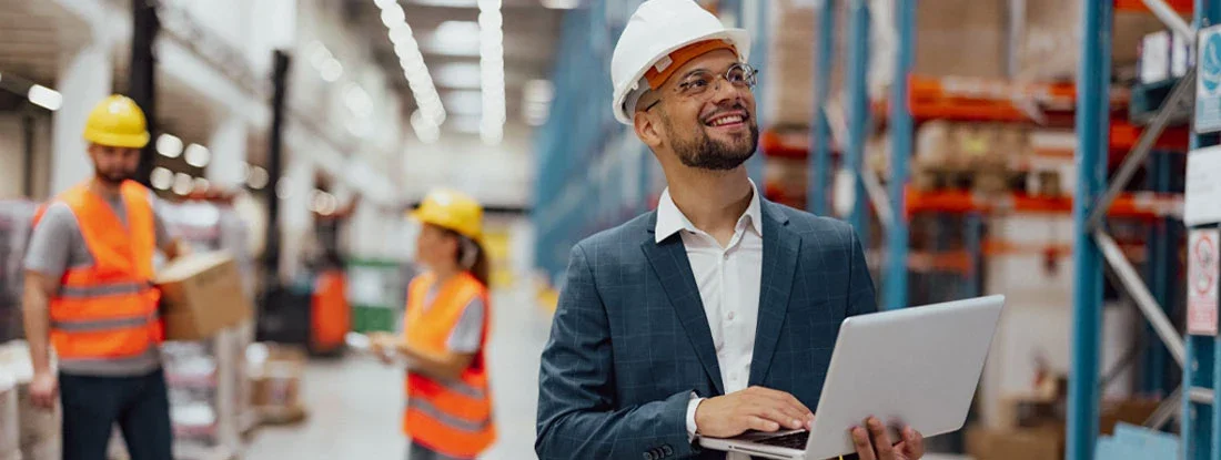 Young businessman using laptop while making distribution plans at warehouse. Do I Need Workers' Compensation Insurance?