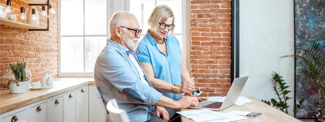 Senior couple with laptop at home. Non Qualified Variable Annuity.