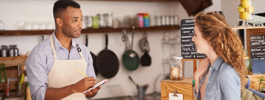 Cafe owner taking an order at a coffee shop. Find Sammamish, Washington business insurance.