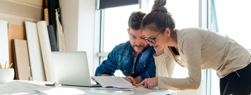 Two coworkers looking at paper document. Find Scottsdale, Arizona business insurance.
