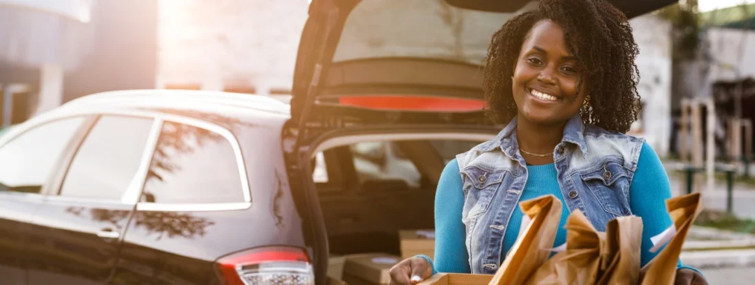 Delivery woman holding a crate with takeaway food orders. Find Virginia Commercial Vehicle Insurance.