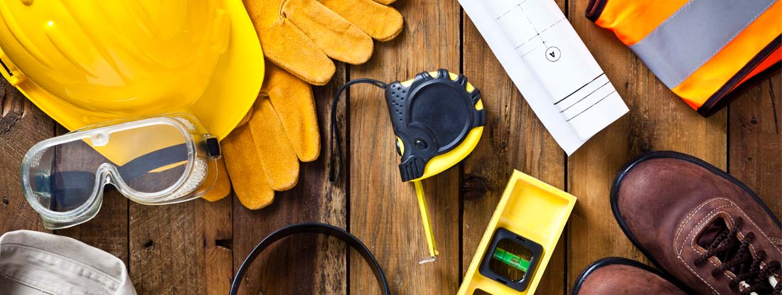 Personal safety workwear and construction blueprint shot directly above. Find Construction insurance in your state.