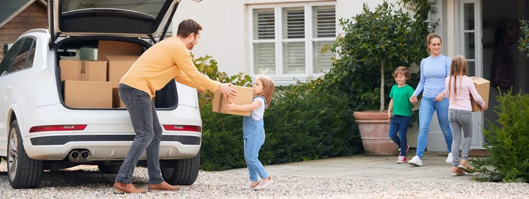 Family Outside New Home On Moving Day Unloading Boxes From Car. Oregon Umbrella Insurance That's Affordable. 