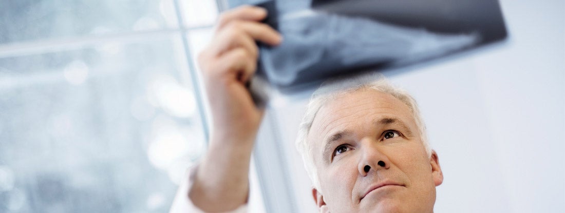 Male Doctor Examining An X-Ray Image. Find Podiatrist Malpractice Insurance.