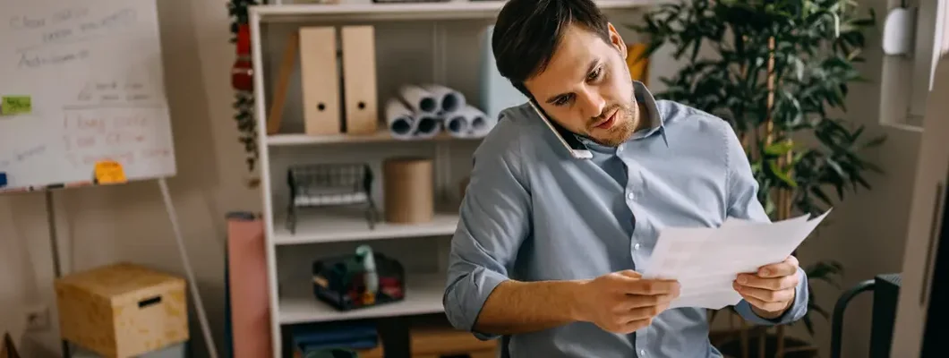 Businessman talking over mobile phone in small office. West Fargo, North Dakota business insurance.