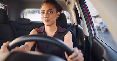 Business woman driving car in city streets. Why Are Car Insurance Rates Going Up in 2023?