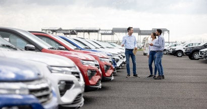 Salesman showing cars to a couple at the dealership. How to Calculate Car Depreciation.