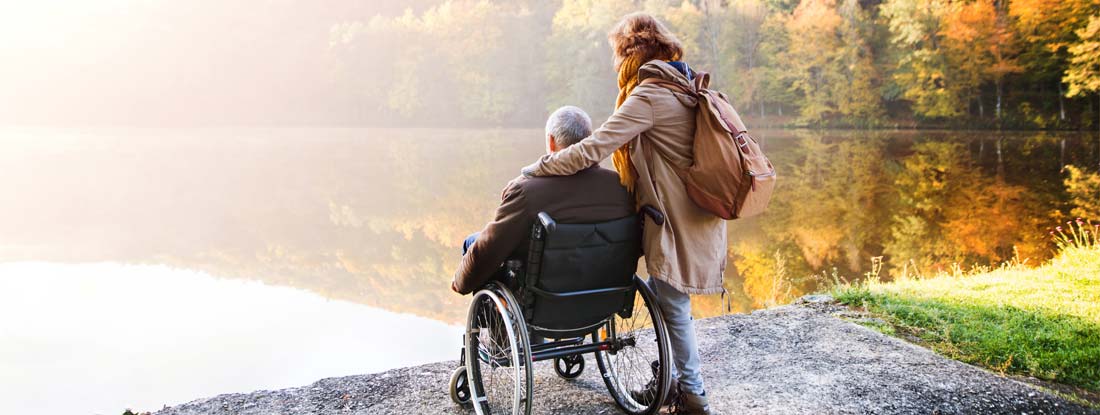 Senior couple enjoying an autumn day by a lake.  Find Residual Disability Insurance.