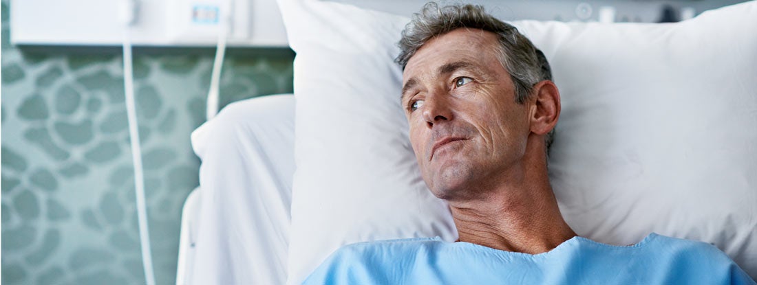 Sick man lying in a hospital bed. Best long term voluntary disability insurance.