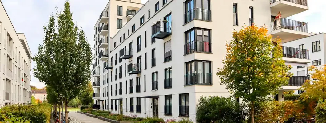 New apartment buildings and green courtyard with pavement and trees in autumn. Find Pennsylvania renters insurance.