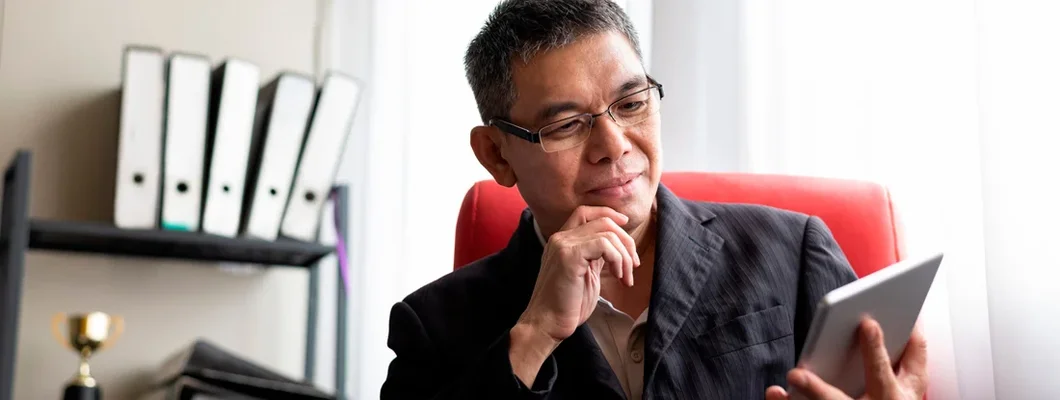 Businessman using digital tablet at office desk.  Find Princeton, New Jersey business insurance.