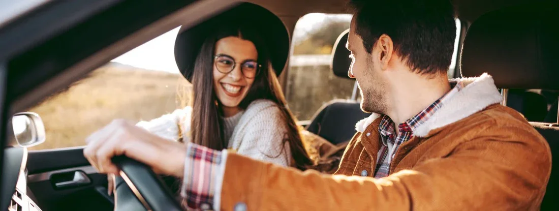 Young couple enjoying a road trip together . Home and Auto Insurance for Unmarried Couples.