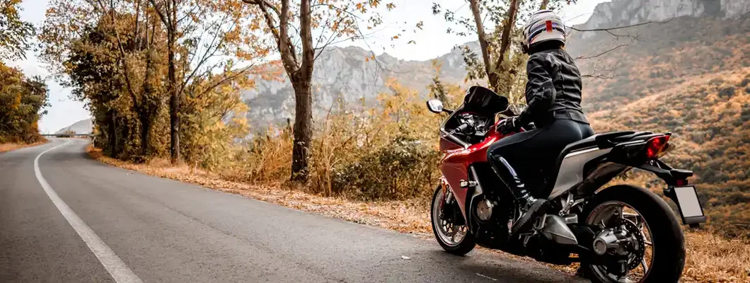 Female biker enjoys view in nature. Motorcycle Insurance Discounts.