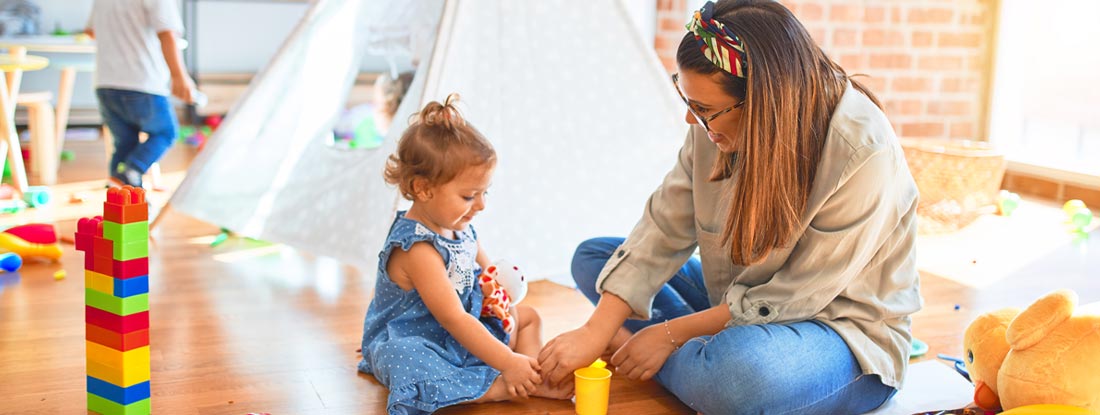 Daycare worker playing with child. Find Mississippi Daycare Insurance.