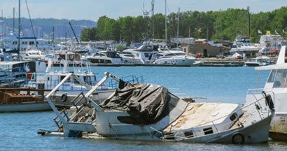 Sunken boat on the pier. Find vandalism to your boat at the marina.