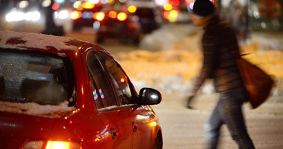 Man in black on crossing street in the winter. Who's responsible if I ran into a pedestrian who was walking outside of the crossing lane?