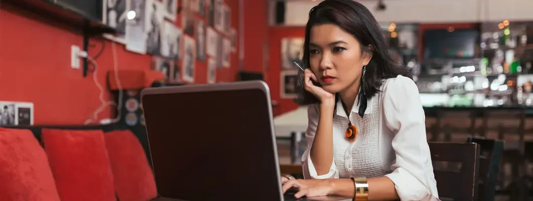 Bar owner using laptop to pay bills online. Leawood, Kansas business insurance.