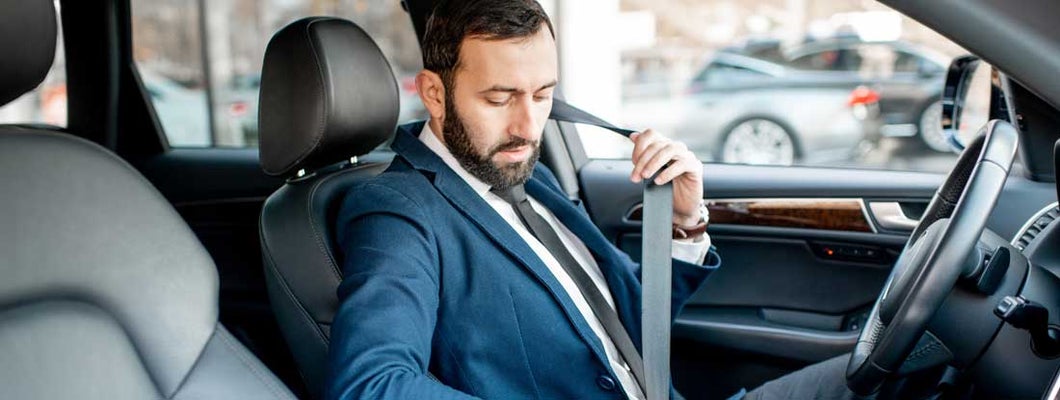 Businessman fastening car safe belt. Find Baltimore Maryland car insurance.