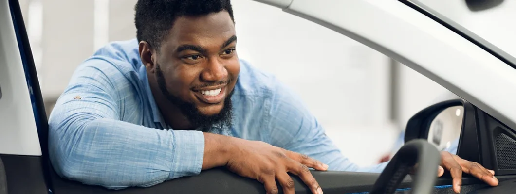 Man Looking At Car Interior In Dealership. New Car Checklist.