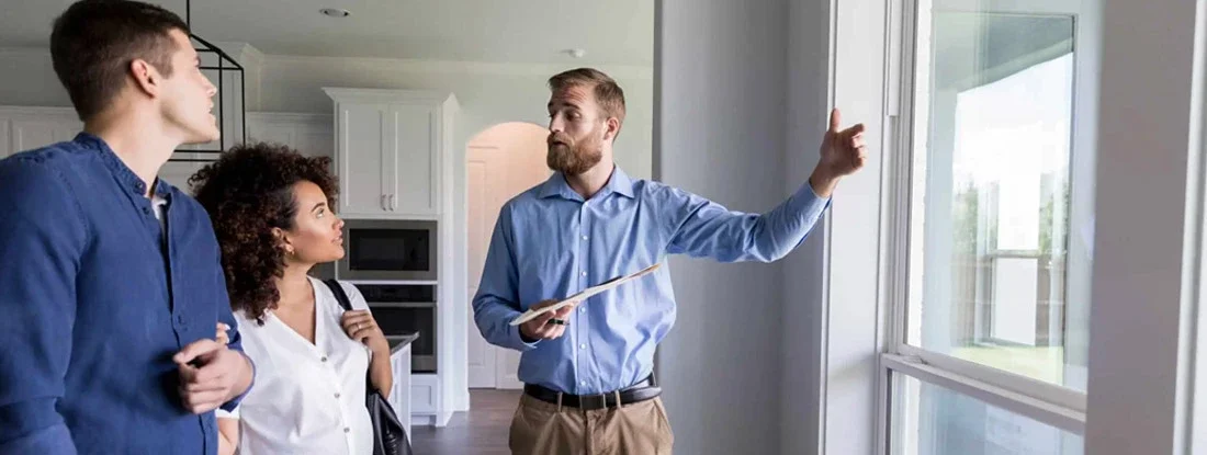 Landlord shows potential renters a view from the living room windows. Find Montana Landlord Insurance.