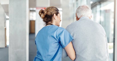 Nurse assisting her senior patient while walking. Find hybrid long term care insurance.
