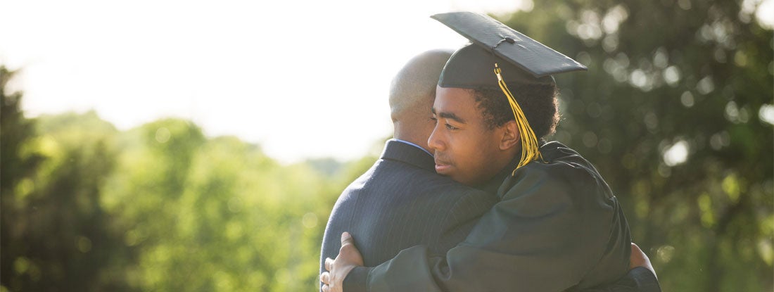 Moment between a graduate and his father. Find Endowment Insurance.