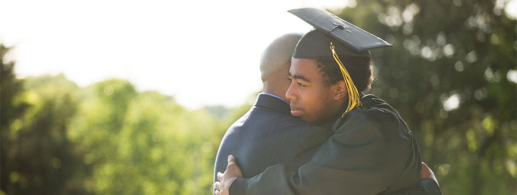 Moment between a graduate and his father. Find Endowment Insurance.