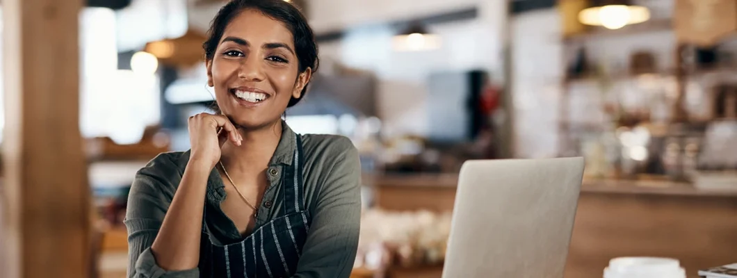 Woman using a laptop while working in a cafe. Business Insurance in East Providence, Rhode Island.