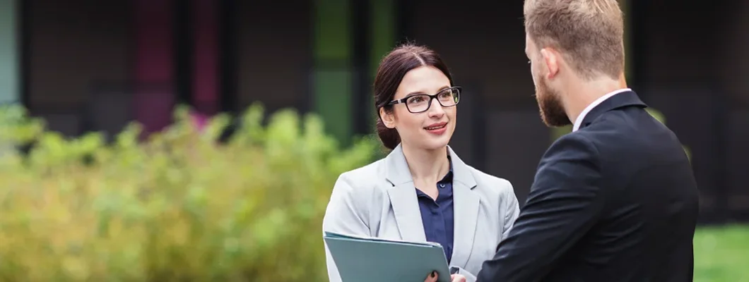 Landlord discussing terms with tenant in front of a residential building. Find Pennsylvania landlord insurance.