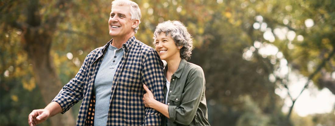 Happy senior couple walking outdoors. Find Joint Life Annuity.