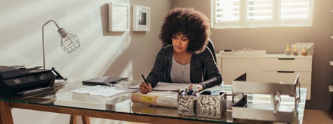 Female interior designer in home office writing business plan