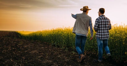 Two farmers walking on a farmland at unset and talking. How Accurate Is the Farmer's Almanac?