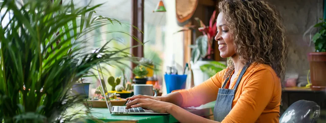 Woman working on a laptop at her flower shop. How to Find the Best Business Insurance in Ridgewood, New Jersey.