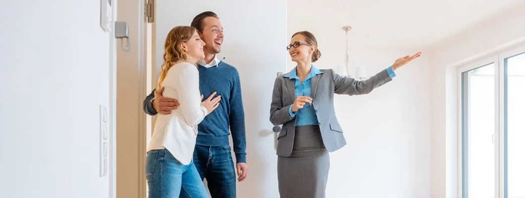 Real Estate Agent showing house to a young couple. Find Iowa Landlord Insurance.