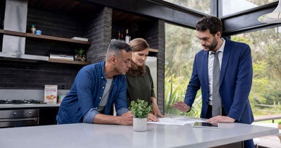 Financial advisor talking to a couple about their real estate investments. Find Maine Landlord Insurance.