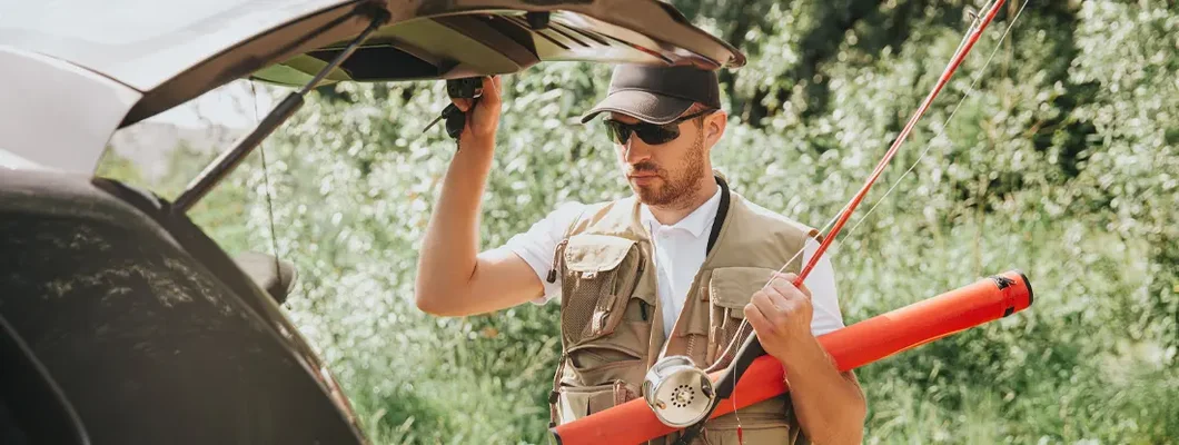 Fisherman holding car's trunk open before fishing. Helena, Montana Car Insurance.
