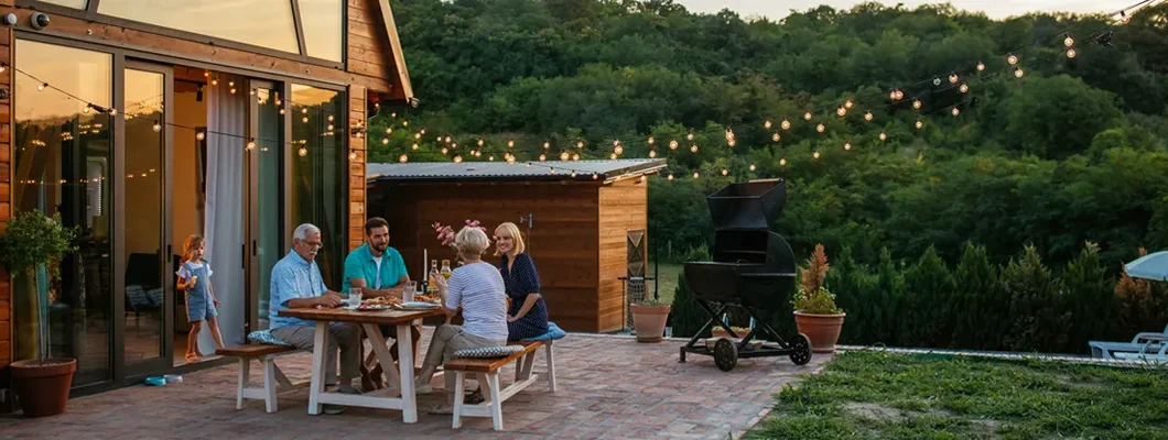 Family dinner around dining table in the backyard. York, Maine Homeowners Insurance.
