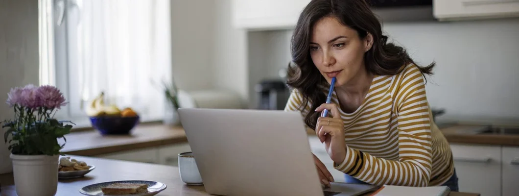 Woman using a laptop while working from home. Is a Car-Buying Service Right For You? 